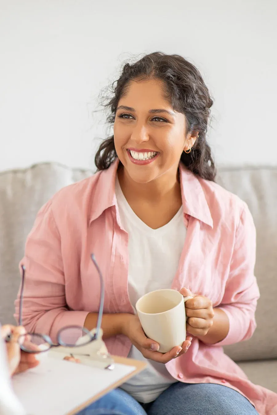 A woman with a mug in warm daylight.