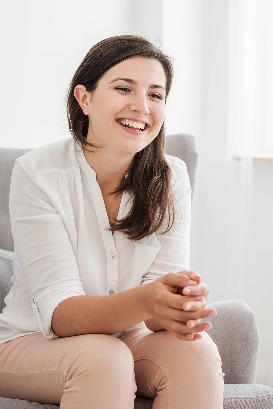 Person sitting and smiling while thinking about addiction treatment programs