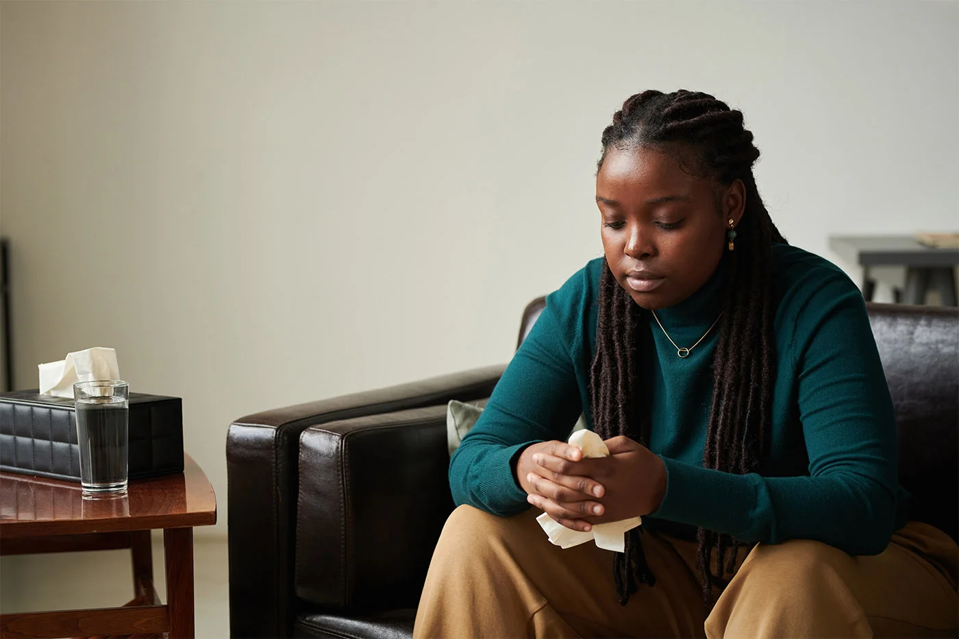 Woman in green sweater crying in addiction treatment